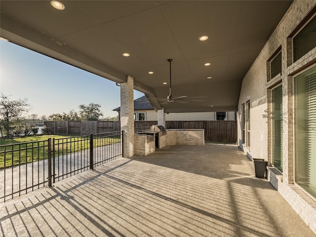 wooden terrace featuring exterior kitchen, a patio area, ceiling fan, and fence