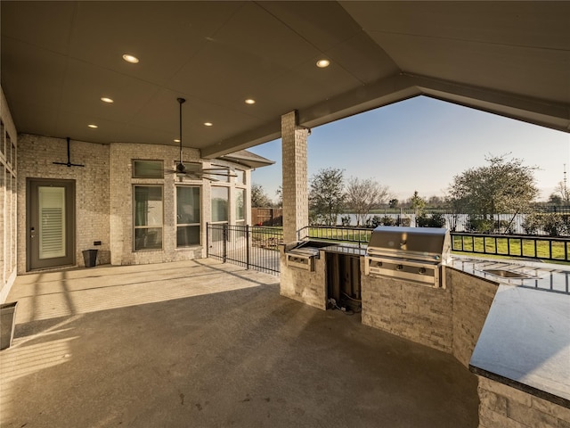 view of patio with area for grilling, a grill, and fence