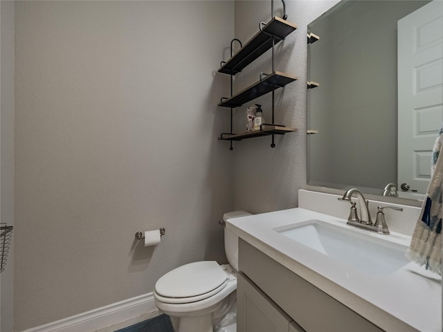 half bath featuring toilet, baseboards, and vanity