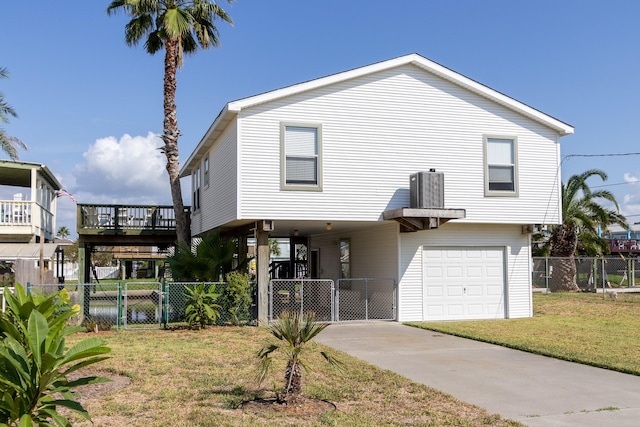 view of front facade with an attached garage, fence, driveway, a carport, and a front yard