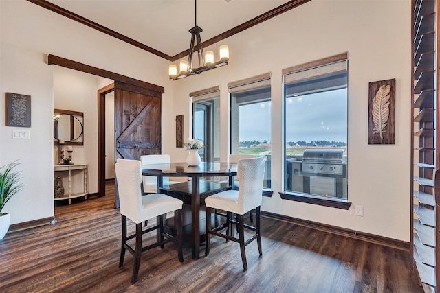 dining room featuring a chandelier, a barn door, baseboards, dark wood-style flooring, and crown molding