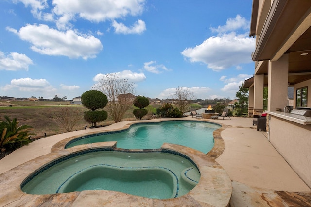 view of swimming pool featuring a fire pit, a pool with connected hot tub, and a patio area