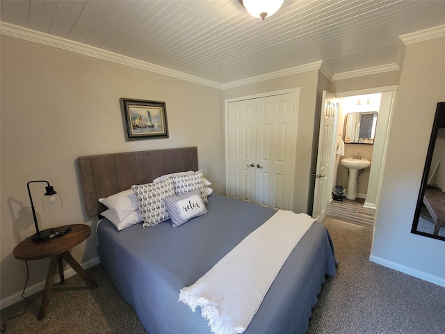 bedroom with dark colored carpet, baseboards, crown molding, and a closet