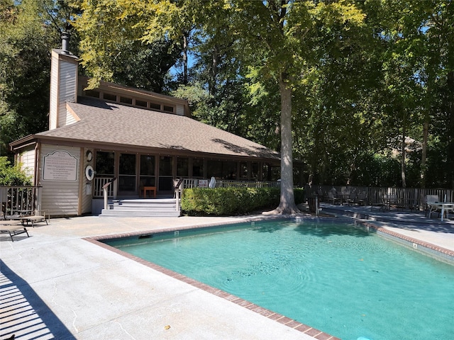 pool with fence, a water slide, and a patio area