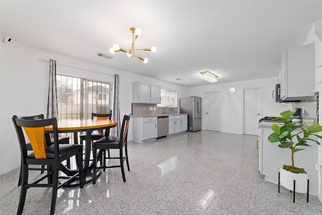 dining area with a notable chandelier and sink