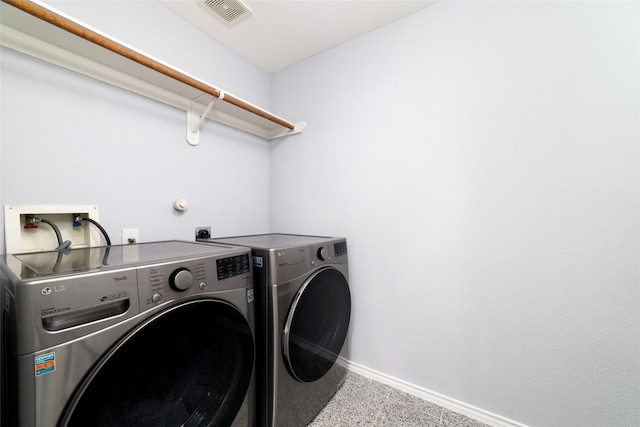 clothes washing area with light colored carpet and washer and dryer