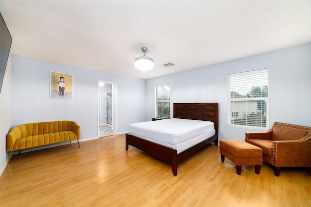 bedroom with light wood-type flooring and multiple windows