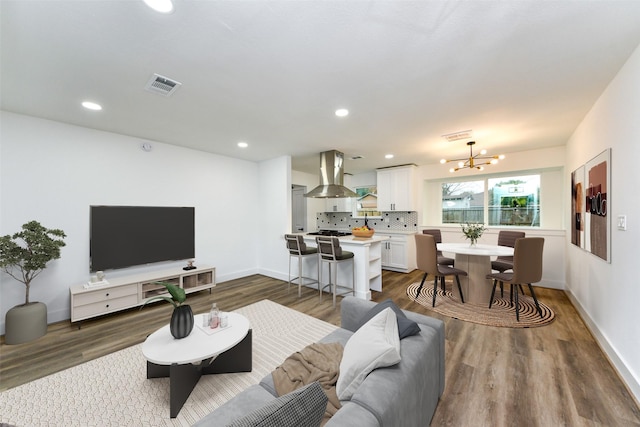 living room featuring a notable chandelier, visible vents, and dark wood-style flooring