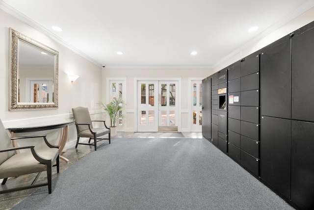 living area with ornamental molding and carpet