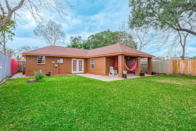 rear view of house with a patio, a yard, and french doors