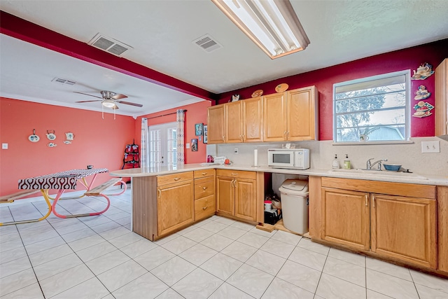 kitchen featuring a healthy amount of sunlight, kitchen peninsula, sink, and french doors