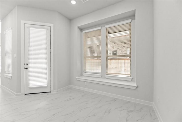 spare room featuring baseboards and marble finish floor