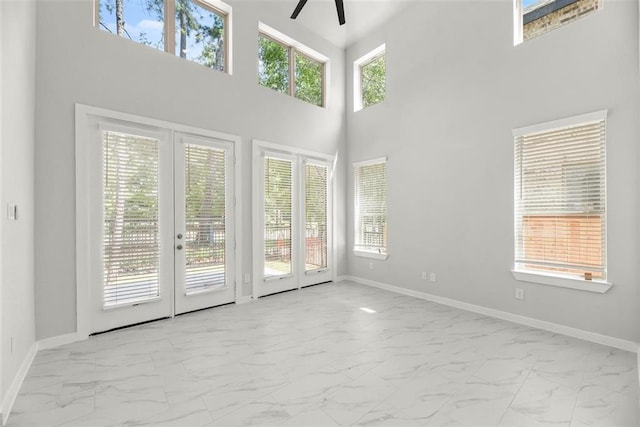 unfurnished room featuring baseboards, french doors, marble finish floor, and ceiling fan