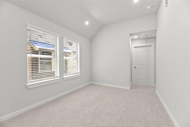 spare room featuring baseboards, attic access, lofted ceiling, recessed lighting, and light colored carpet