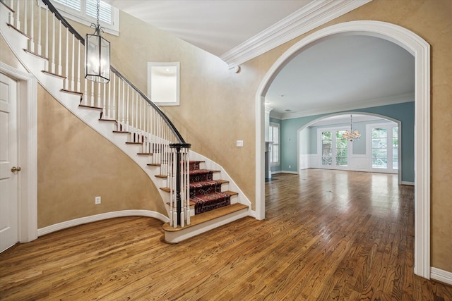 entryway featuring stairs, ornamental molding, wood finished floors, and baseboards