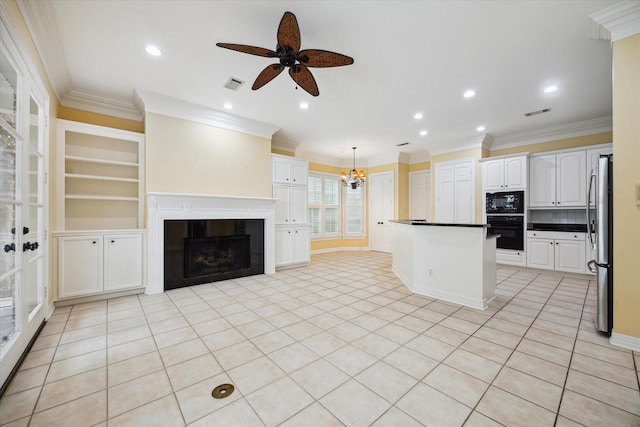 kitchen featuring visible vents, dark countertops, freestanding refrigerator, hanging light fixtures, and white cabinetry