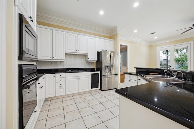 kitchen featuring dark countertops, white cabinets, a sink, and black appliances