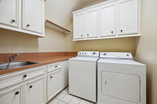 laundry area with cabinet space, light tile patterned floors, separate washer and dryer, and a sink