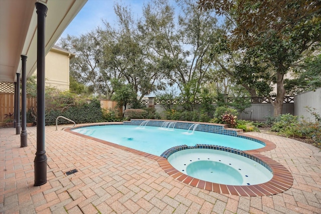 view of pool featuring a patio, a fenced backyard, and a pool with connected hot tub