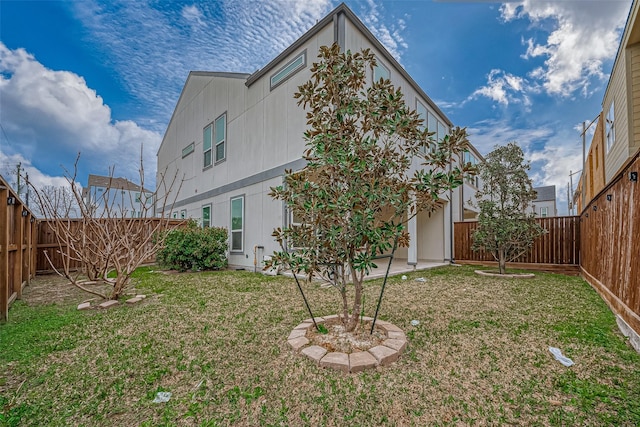 back of property featuring a yard, a patio, and a fenced backyard