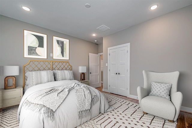 bedroom featuring visible vents, baseboards, wood finished floors, a closet, and recessed lighting