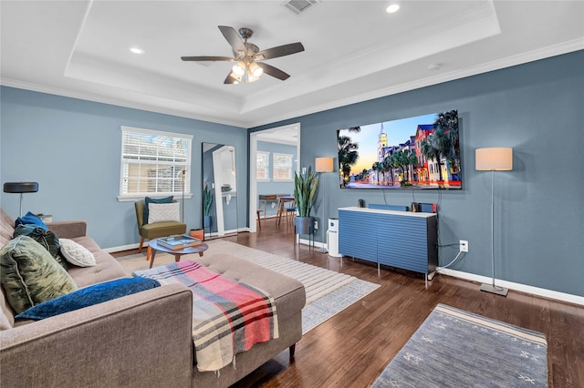 living room featuring ornamental molding, a raised ceiling, and dark hardwood / wood-style floors