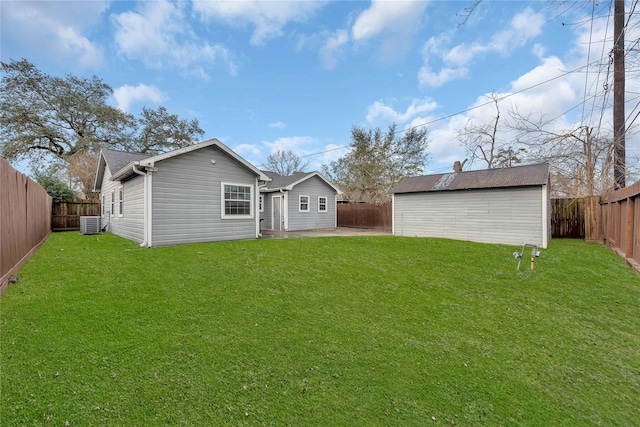 rear view of property with a lawn, cooling unit, and a storage shed