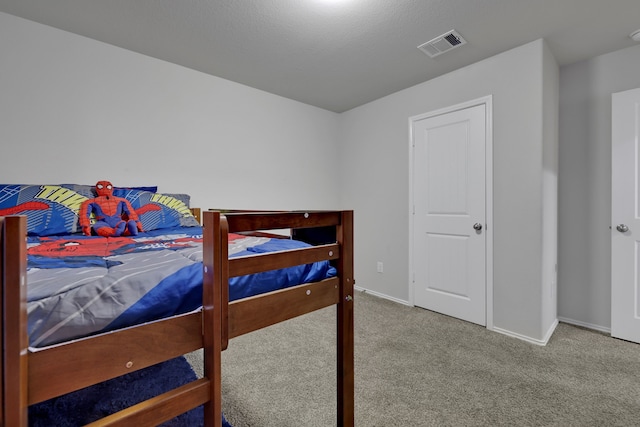 bedroom with baseboards, visible vents, and carpet