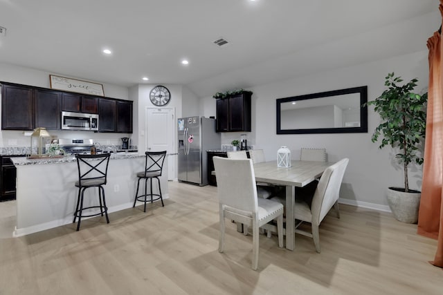 dining room with light wood-type flooring, visible vents, recessed lighting, and baseboards