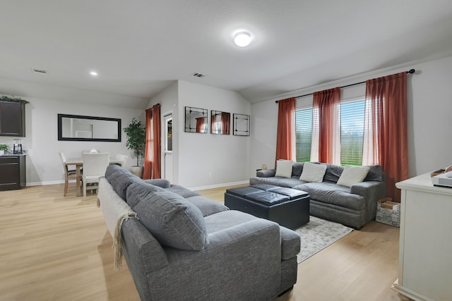 living room featuring baseboards, visible vents, and light wood-style floors