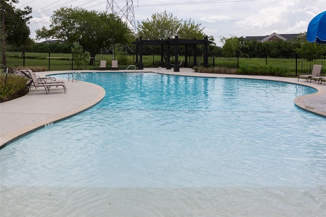 pool with a pergola, a patio, and fence