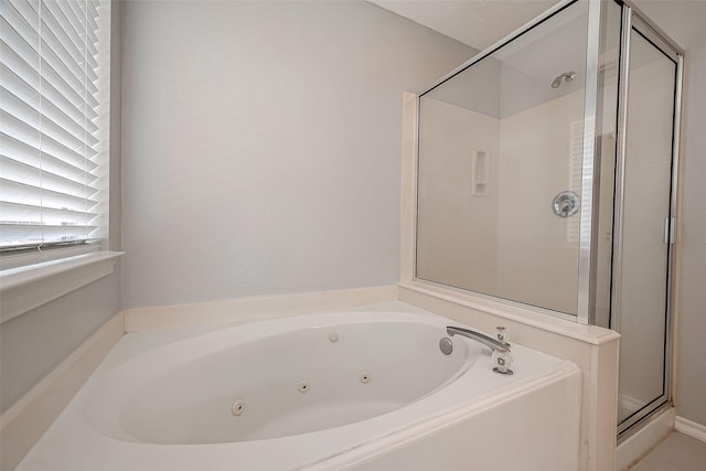 bathroom with a shower stall and a tub with jets