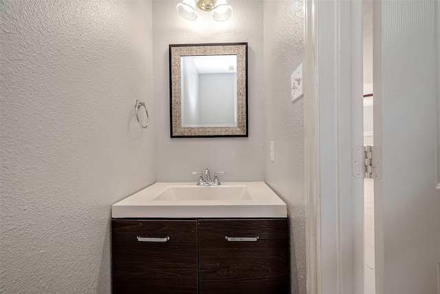 bathroom featuring vanity and a textured wall