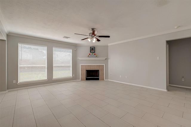 unfurnished living room featuring ornamental molding, visible vents, baseboards, a tiled fireplace, and a ceiling fan