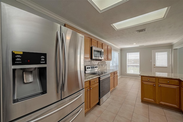 kitchen featuring ornamental molding, visible vents, decorative backsplash, appliances with stainless steel finishes, and light tile patterned flooring