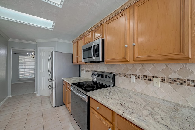 kitchen featuring light stone counters, crown molding, light tile patterned floors, backsplash, and stainless steel appliances