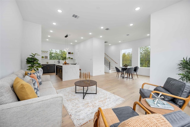 living area with stairway, recessed lighting, visible vents, and light wood-style floors