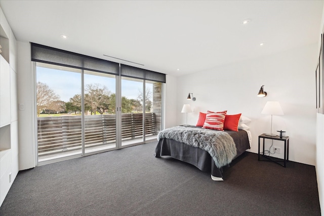 bedroom with a wall of windows, dark carpet, recessed lighting, and access to outside