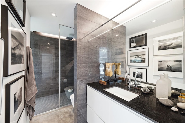 bathroom featuring a walk in shower, vanity, toilet, and tile walls