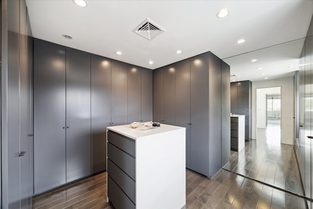 walk in closet with dark wood-style flooring and visible vents