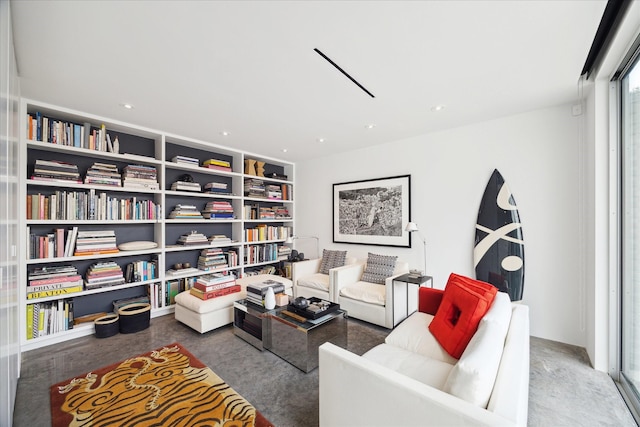 sitting room with built in shelves and concrete floors