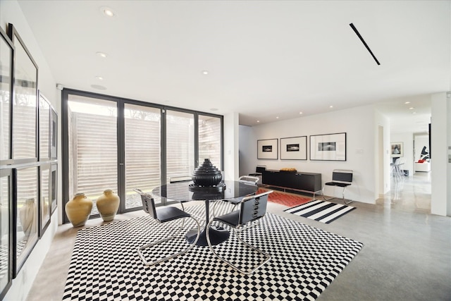 living area featuring a wall of windows, recessed lighting, and finished concrete floors