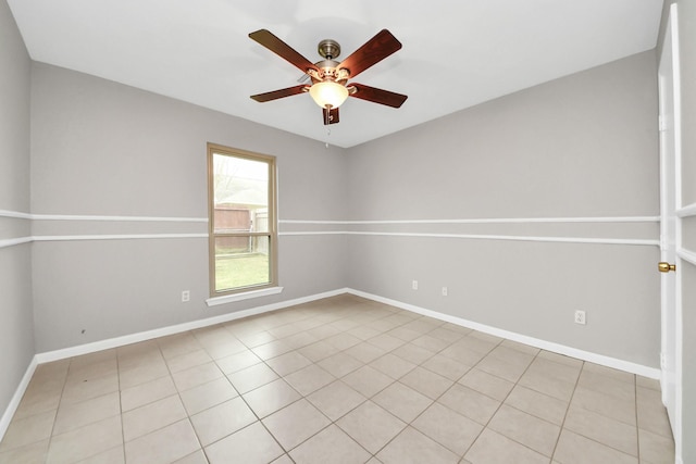 empty room featuring baseboards, a ceiling fan, and light tile patterned flooring