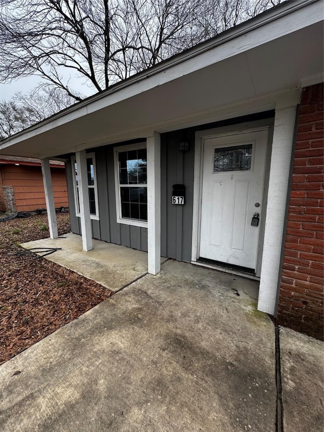 entrance to property with brick siding and board and batten siding