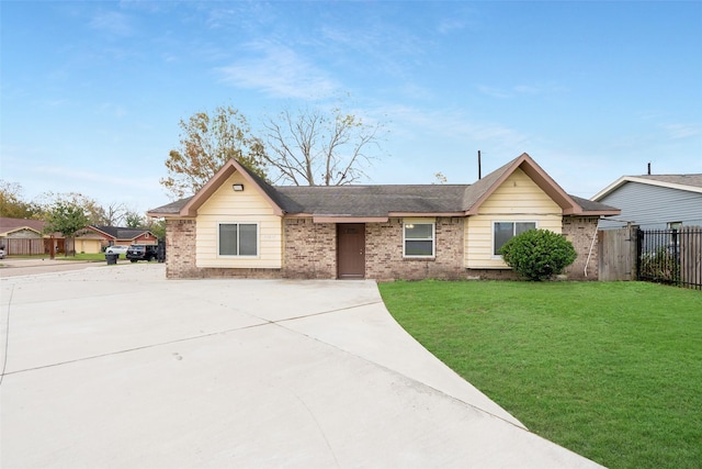 ranch-style house featuring fence, concrete driveway, a front lawn, and brick siding