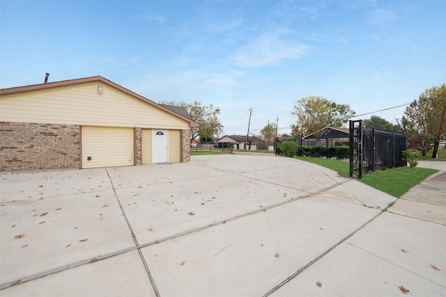 exterior space featuring fence, brick siding, and a detached garage