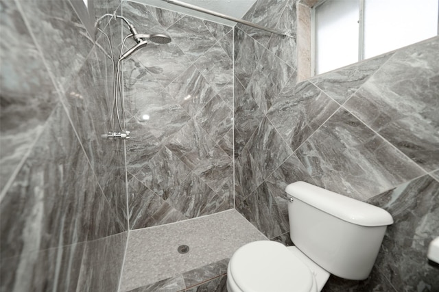 full bathroom featuring tile walls, toilet, and a stall shower