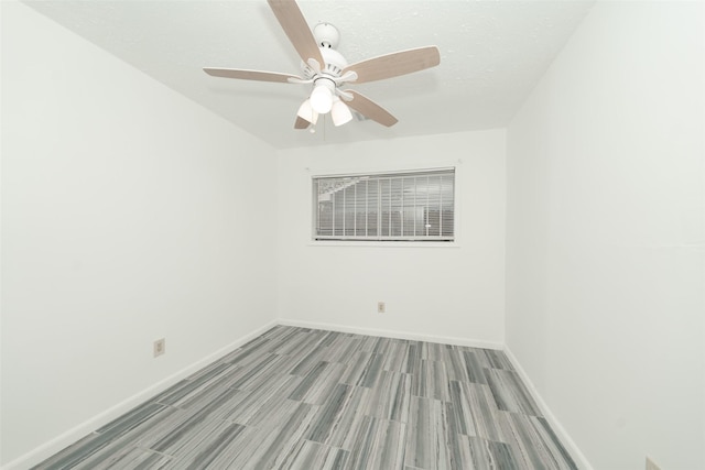 unfurnished room featuring baseboards, wood finish floors, and ceiling fan