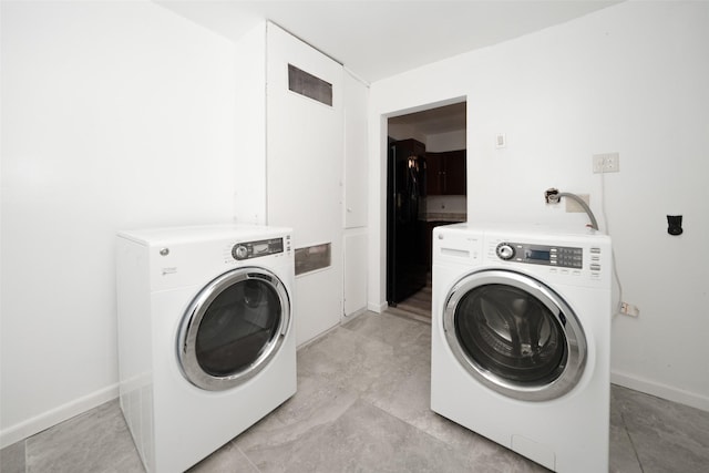 washroom featuring independent washer and dryer, baseboards, and laundry area