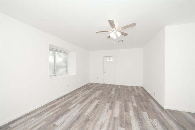 unfurnished room featuring a ceiling fan, light wood finished floors, baseboards, and visible vents